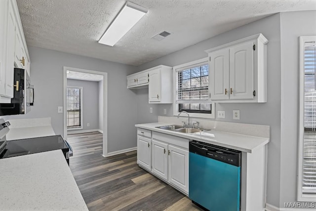 kitchen featuring stainless steel appliances, dark wood-style flooring, a sink, visible vents, and white cabinets