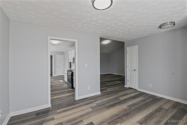 empty room with dark wood-style floors, baseboards, and a textured ceiling