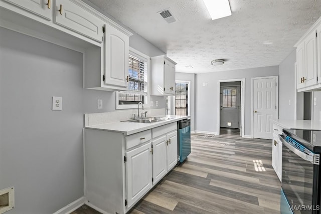 kitchen with white cabinets, stainless steel appliances, a sink, and light countertops