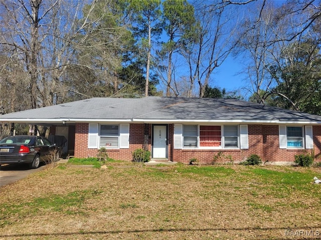 ranch-style home featuring an attached carport, brick siding, and a front lawn