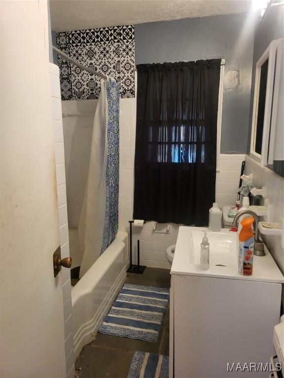 bathroom featuring toilet, vanity, shower / bath combination with curtain, and tile walls