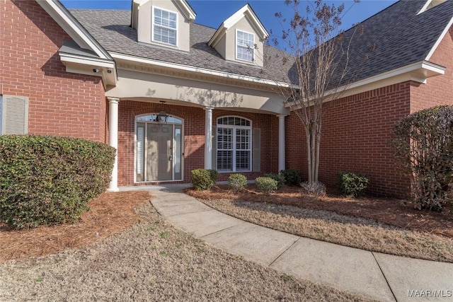 property entrance with brick siding and roof with shingles