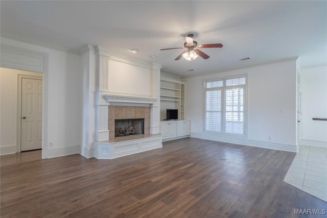 unfurnished living room featuring ornamental molding, dark wood finished floors, visible vents, and a fireplace