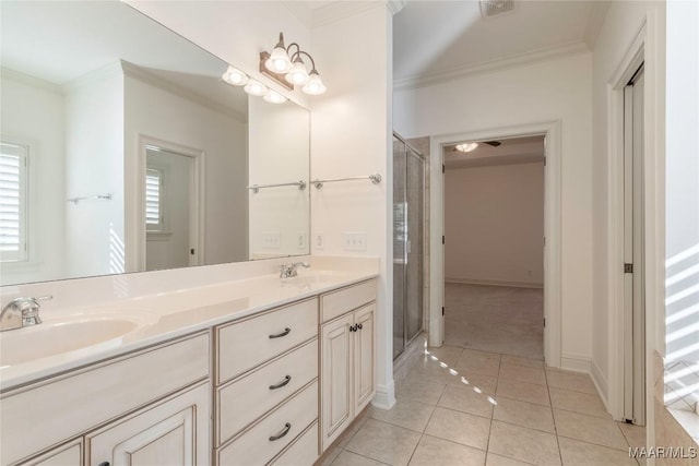 bathroom with a sink, a shower stall, crown molding, and tile patterned floors