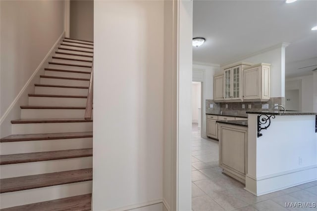 stairs with ornamental molding and tile patterned floors