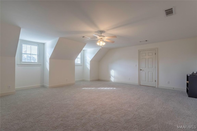 additional living space with light colored carpet, visible vents, and plenty of natural light