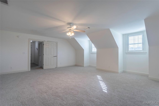 additional living space featuring visible vents, plenty of natural light, and light carpet