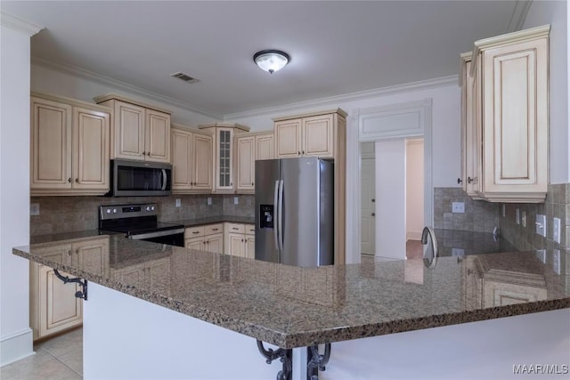 kitchen with stainless steel appliances, visible vents, glass insert cabinets, a peninsula, and a kitchen bar