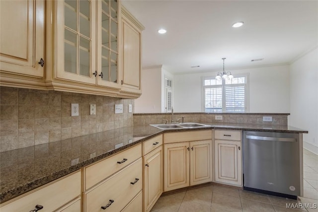 kitchen with glass insert cabinets, a sink, hanging light fixtures, and stainless steel dishwasher