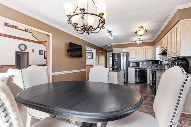 dining space with dark wood-style floors, crown molding, a textured ceiling, and an inviting chandelier