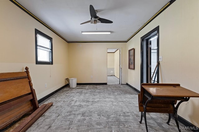 interior space featuring ornamental molding, baseboards, and a ceiling fan