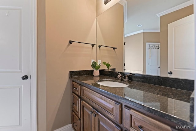 bathroom with visible vents, crown molding, vanity, and baseboards