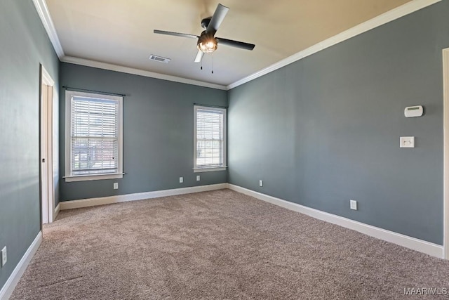 spare room with baseboards, carpet, visible vents, and crown molding