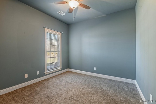 carpeted empty room with ceiling fan, visible vents, and baseboards