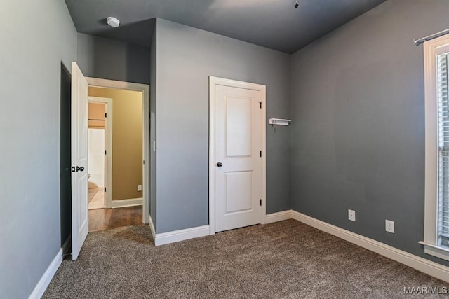 unfurnished bedroom featuring carpet and baseboards