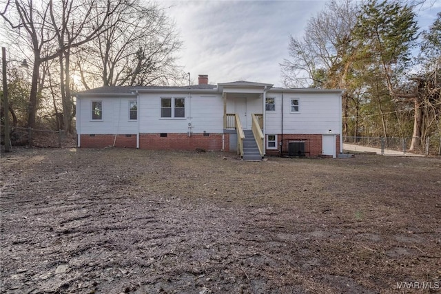 back of house featuring crawl space, a chimney, and fence