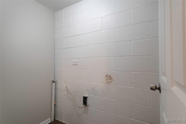 laundry room featuring concrete block wall