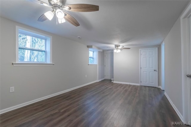 empty room featuring ceiling fan, dark wood-type flooring, and baseboards