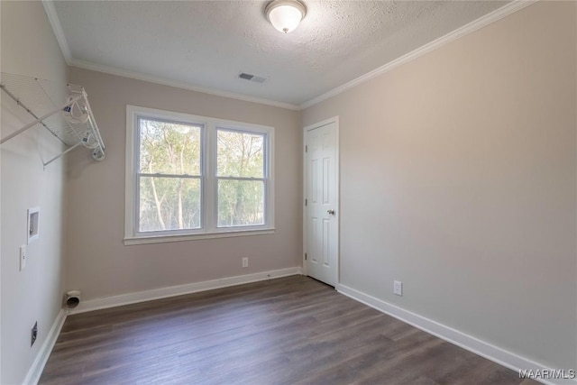 empty room featuring crown molding, visible vents, a textured ceiling, wood finished floors, and baseboards