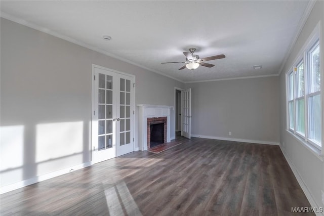 unfurnished living room featuring baseboards, dark wood-style floors, crown molding, french doors, and a brick fireplace