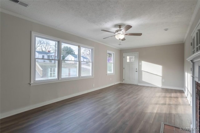 unfurnished living room featuring crown molding, dark wood-style flooring, visible vents, and a fireplace