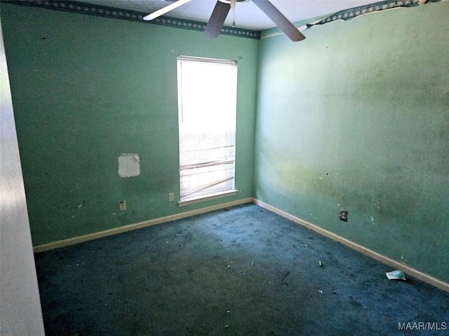 carpeted spare room featuring ceiling fan and baseboards