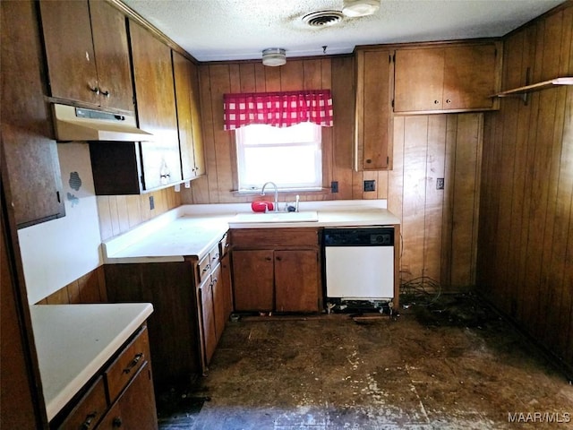 kitchen with light countertops, visible vents, a sink, dishwasher, and under cabinet range hood