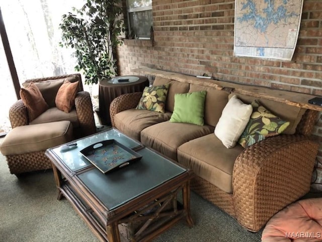 living room with carpet floors and brick wall