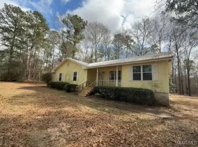 view of front facade featuring a porch and metal roof