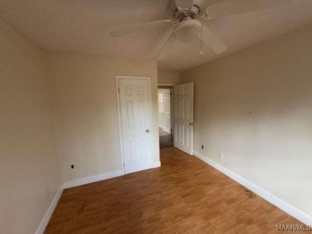 unfurnished bedroom featuring baseboards, a ceiling fan, and light wood-style floors