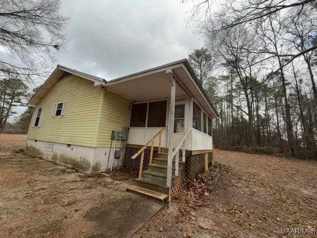 view of front facade featuring stairway, crawl space, and a sunroom