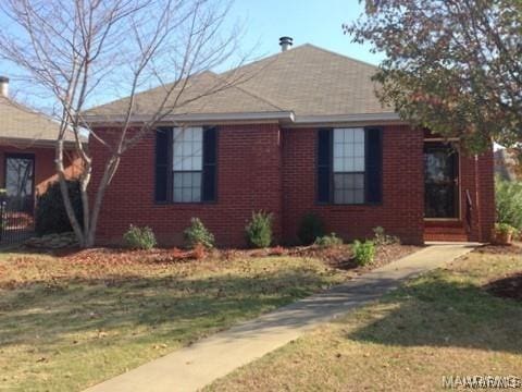 view of front facade with a front yard and brick siding