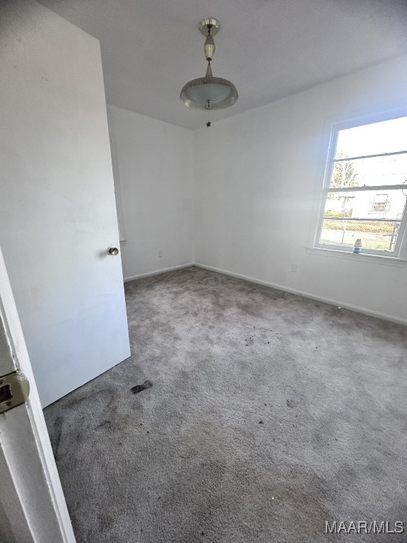 unfurnished room featuring carpet flooring and baseboards