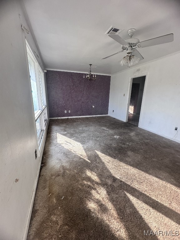 unfurnished room featuring carpet floors, a notable chandelier, visible vents, and crown molding