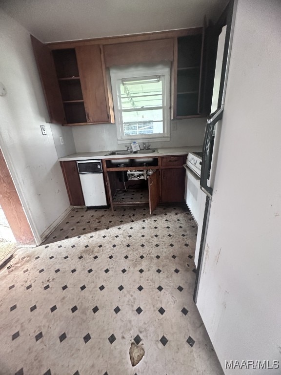 kitchen featuring light floors, white appliances, a sink, light countertops, and open shelves