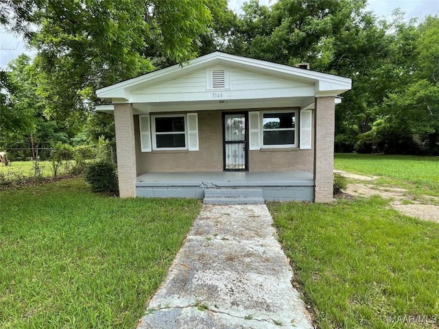 bungalow-style home with covered porch, brick siding, a front lawn, and fence