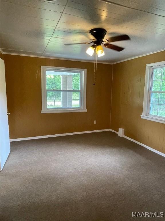 carpeted spare room featuring baseboards, ornamental molding, and a ceiling fan