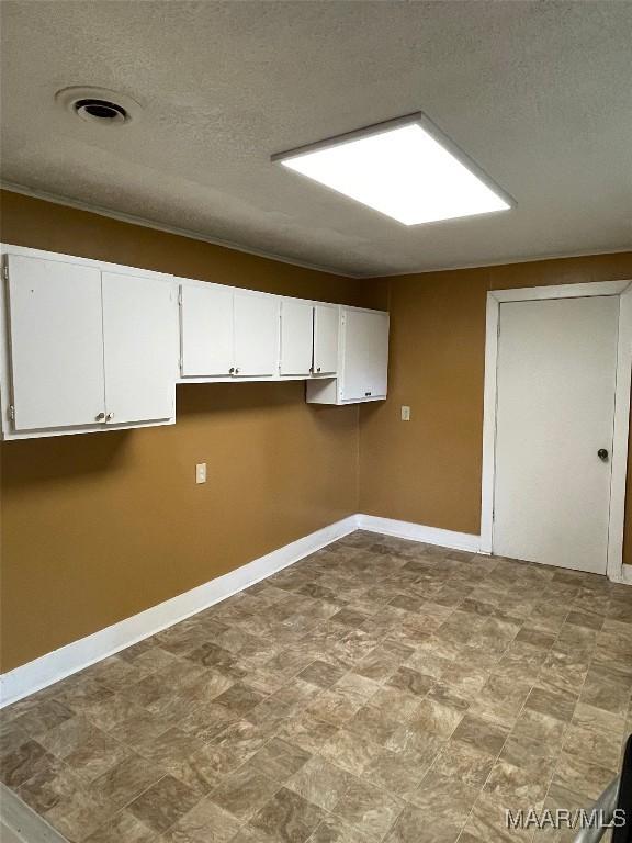 washroom featuring a textured ceiling and baseboards