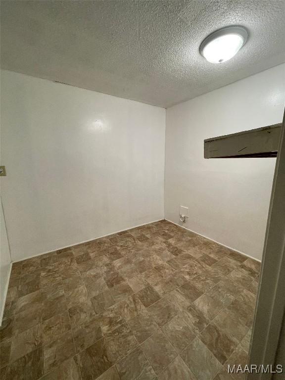 unfurnished room with a textured ceiling