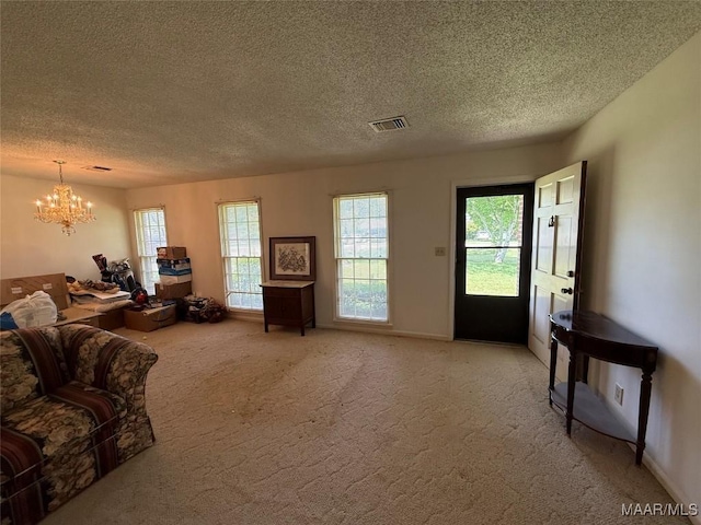 20 Glendale Dr, Selma, AL 36701 - living area with baseboards, a chandelier, a textured ceiling, visible vents, and light colored carpet
