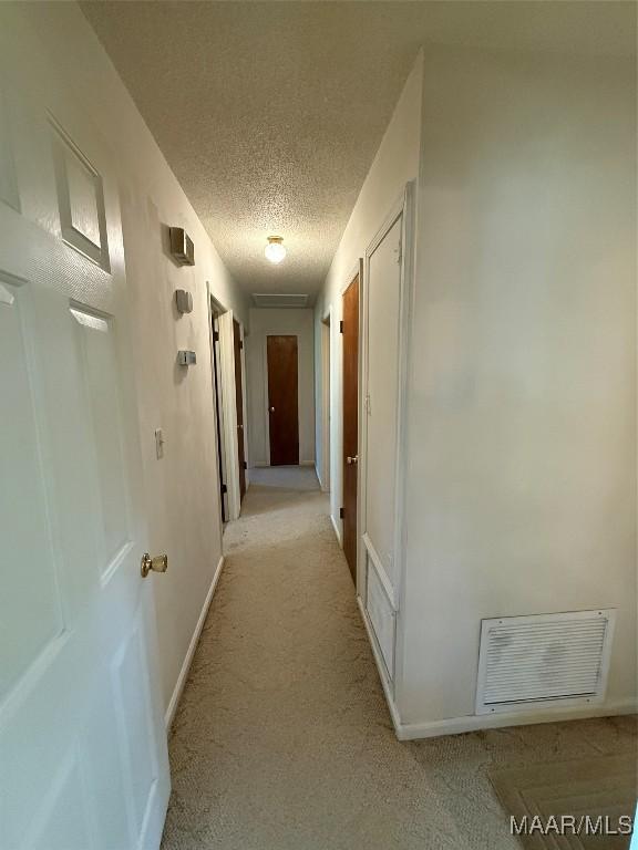 20 Glendale Dr, Selma, AL 36701 - hallway featuring visible vents, baseboards, light colored carpet, and a textured ceiling