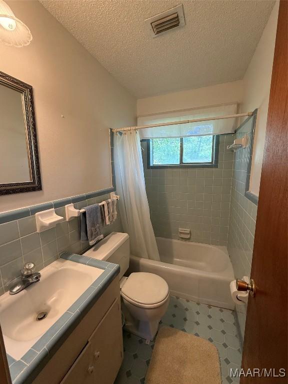 20 Glendale Dr, Selma, AL 36701 - bathroom with visible vents, toilet, tile walls, a textured ceiling, and tile patterned floors