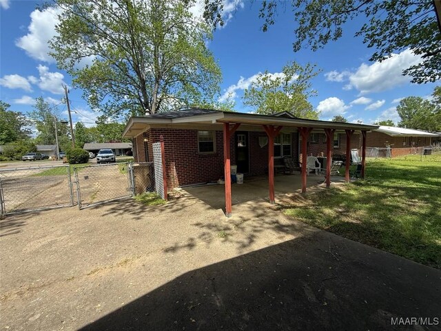 20 Glendale Dr, Selma, AL 36701 - back of house featuring a gate, driveway, brick siding, a yard, and fence