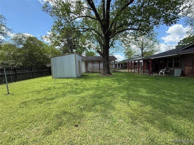20 Glendale Dr, Selma, AL 36701 - view of yard featuring central AC unit, a patio area, a fenced backyard, a storage unit, and an outbuilding