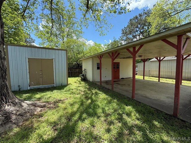 20 Glendale Dr, Selma, AL 36701 - view of yard featuring a carport, a patio, an outbuilding, fence, and a storage unit