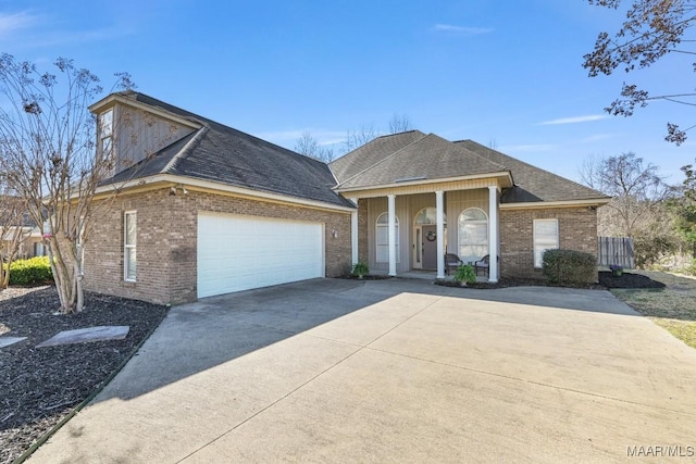 view of front facade with a porch, a garage, brick siding, a shingled roof, and concrete driveway