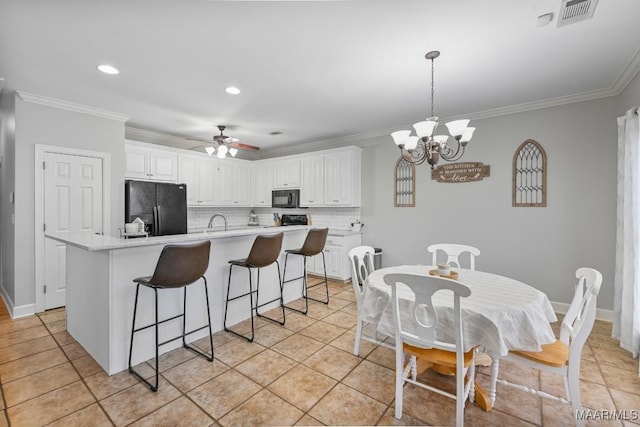 kitchen with black appliances, visible vents, and crown molding