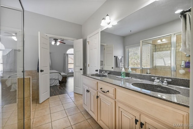 ensuite bathroom with tile patterned floors, a sink, and a shower stall