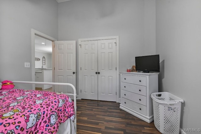 bedroom with dark wood-type flooring and a closet