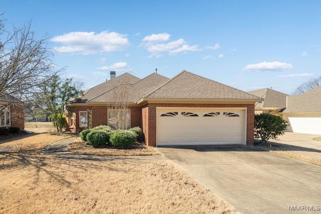 view of front facade featuring an attached garage, a shingled roof, concrete driveway, and brick siding